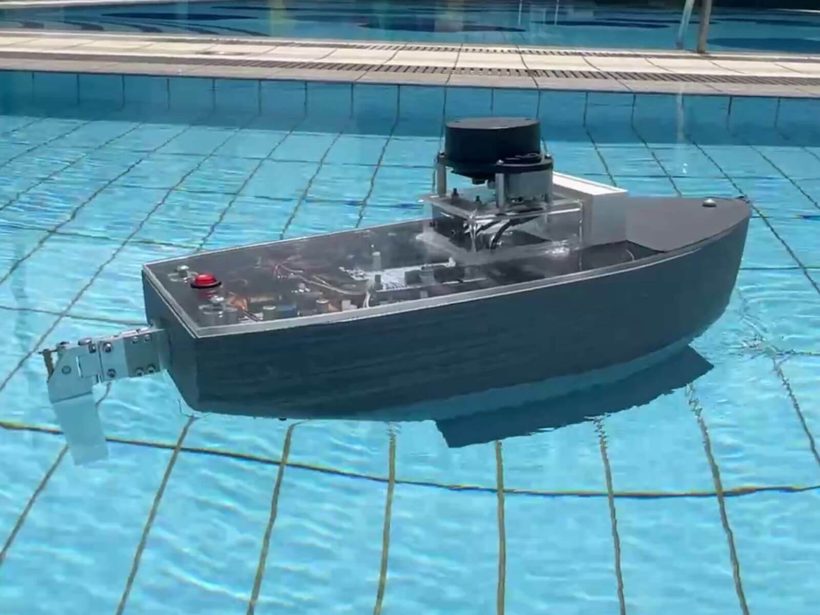 A student-created craft that resembles a boat floats in a pool