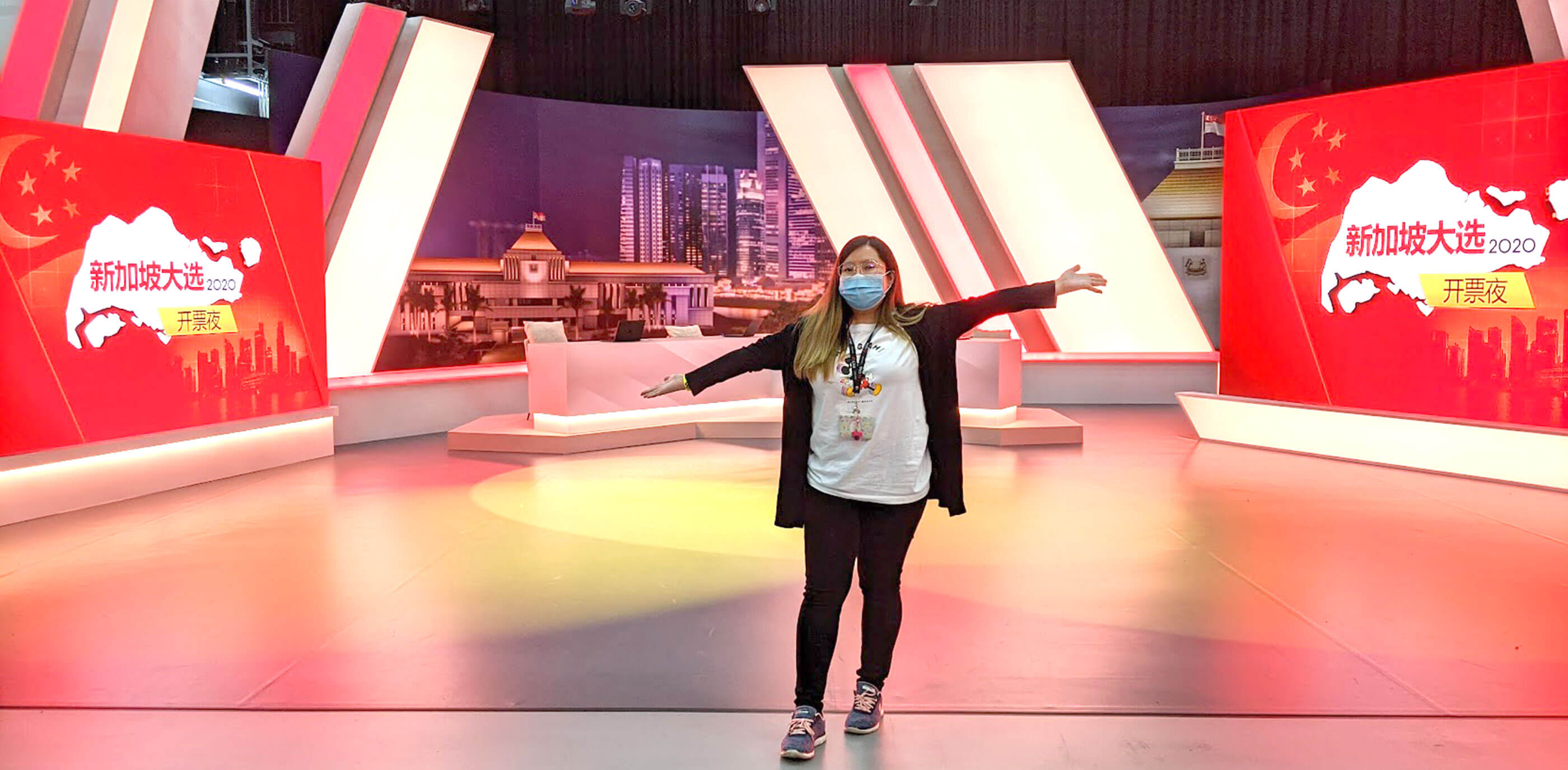 DigiPen alumna Carmen Chan stands on the set of a TV news show.