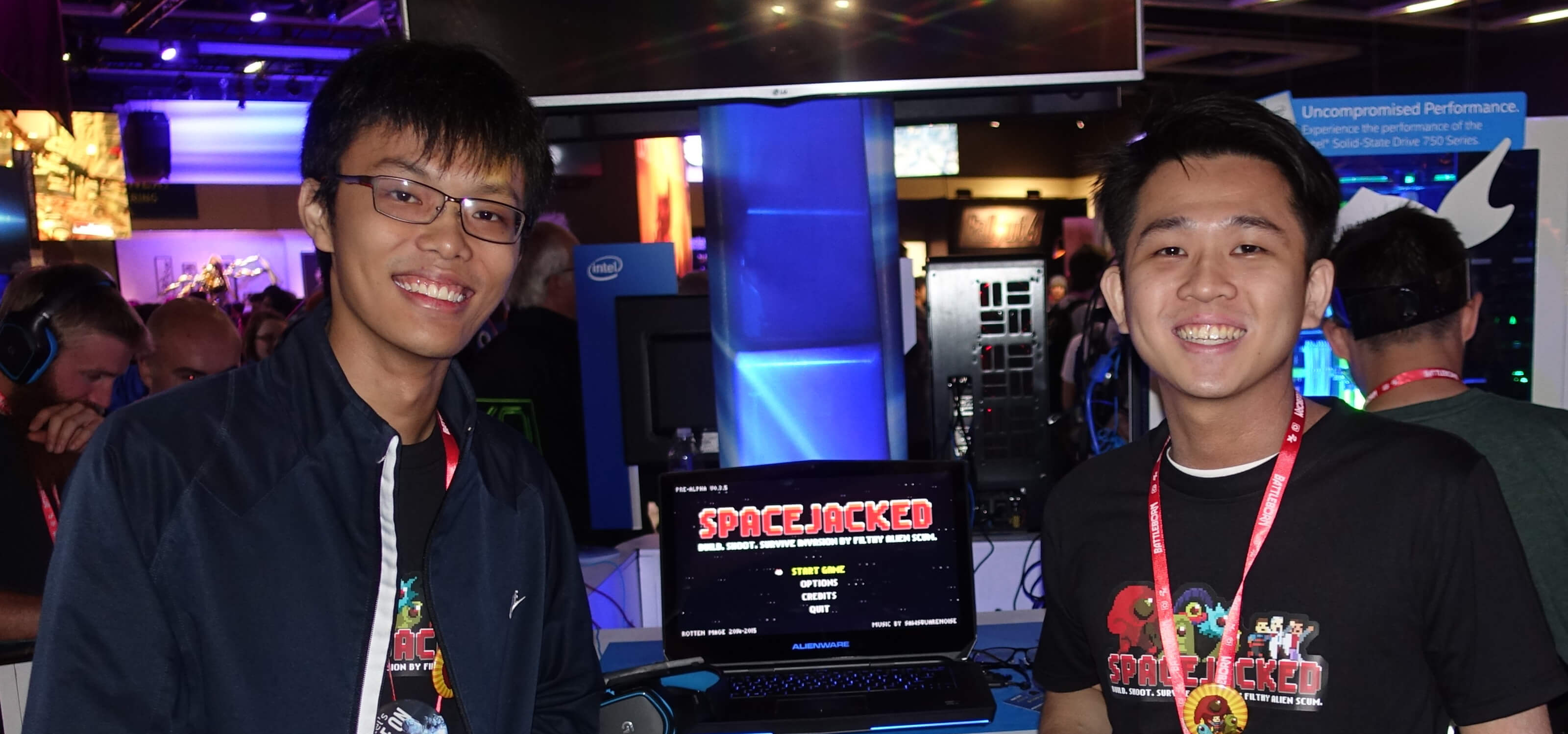 DigiPen (Singapore) graduates Chin Yong Kian and Lim Chian Song stand next to a demo of their game, Spacejacked.