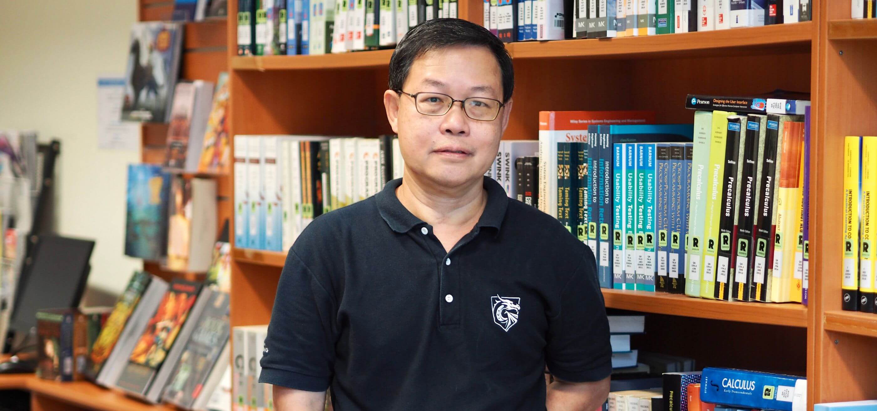 DigiPen Singapore Dept. Chair Fong Foo Hoong poses for a photo next to a bookcase