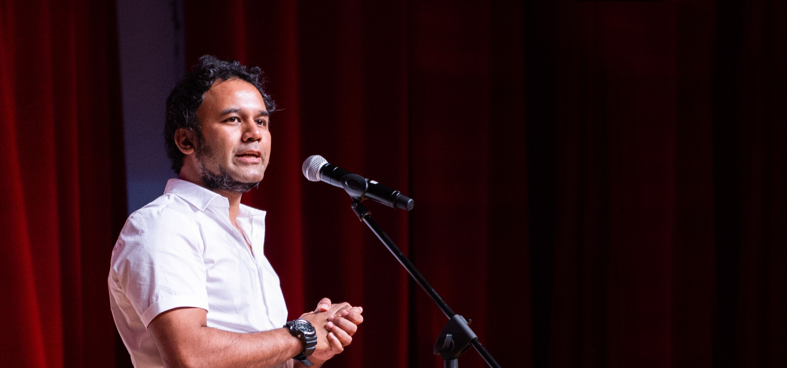 Rahul Nath stands before a microphone.