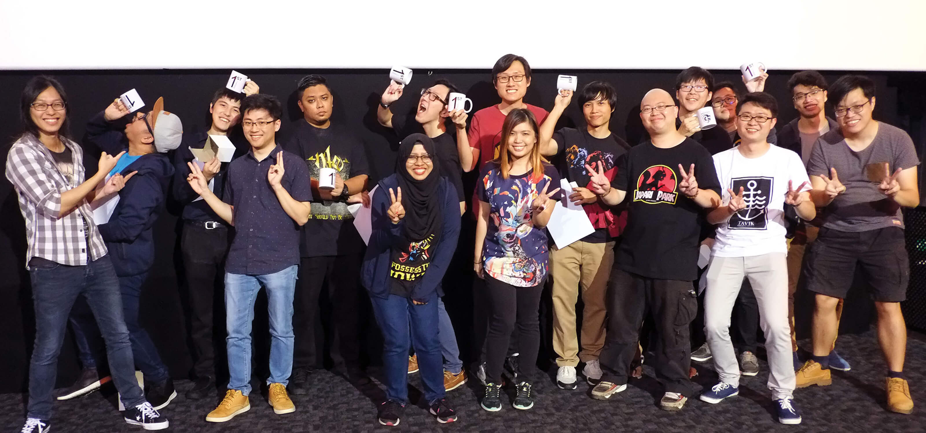 The pioneering members of the DigiPen (Singapore) Alumni Committee pose with mugs emblazoned with the number one