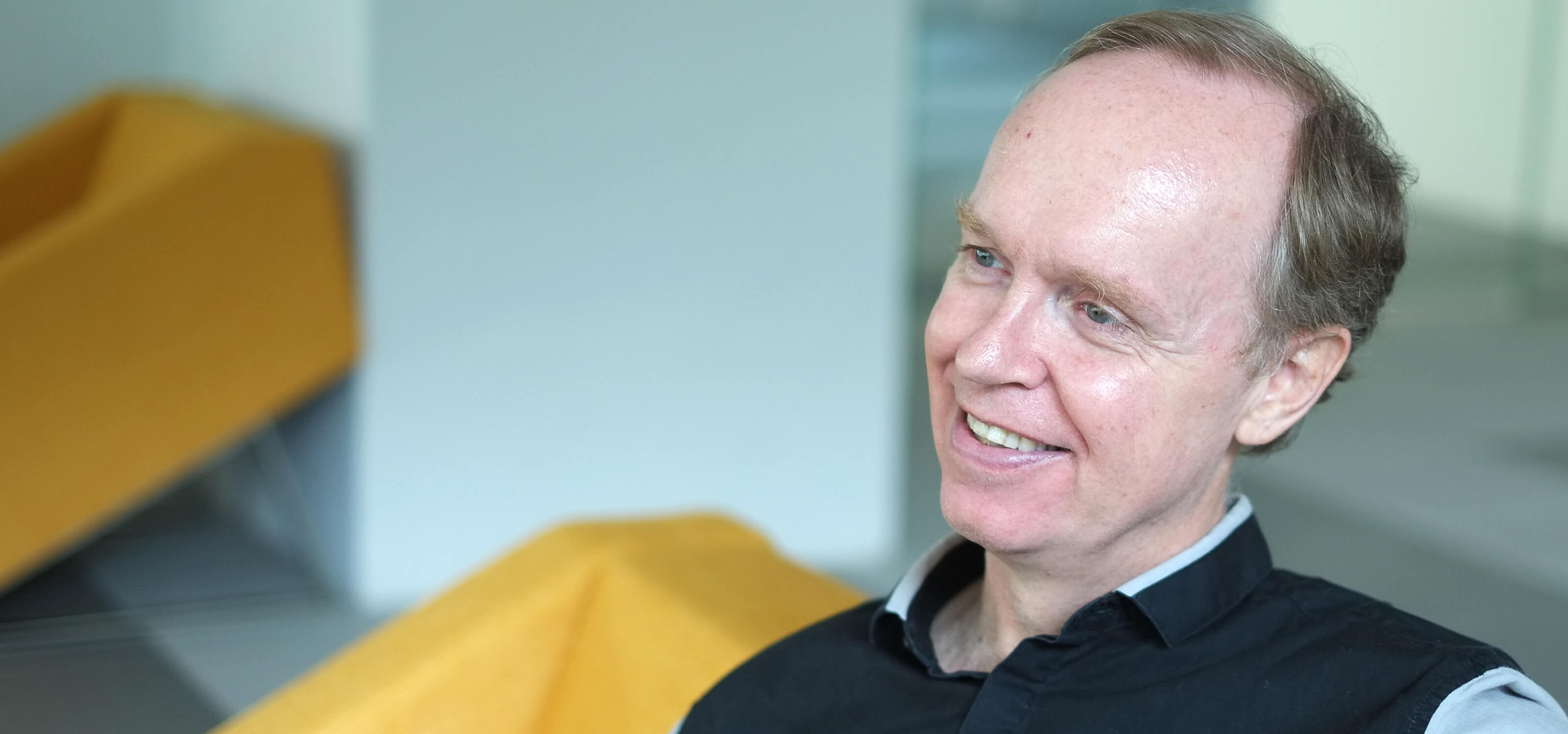 Department Chair of Game Software Design and Production, Joe McGinn, poses for a photo sitting on a yellow chair