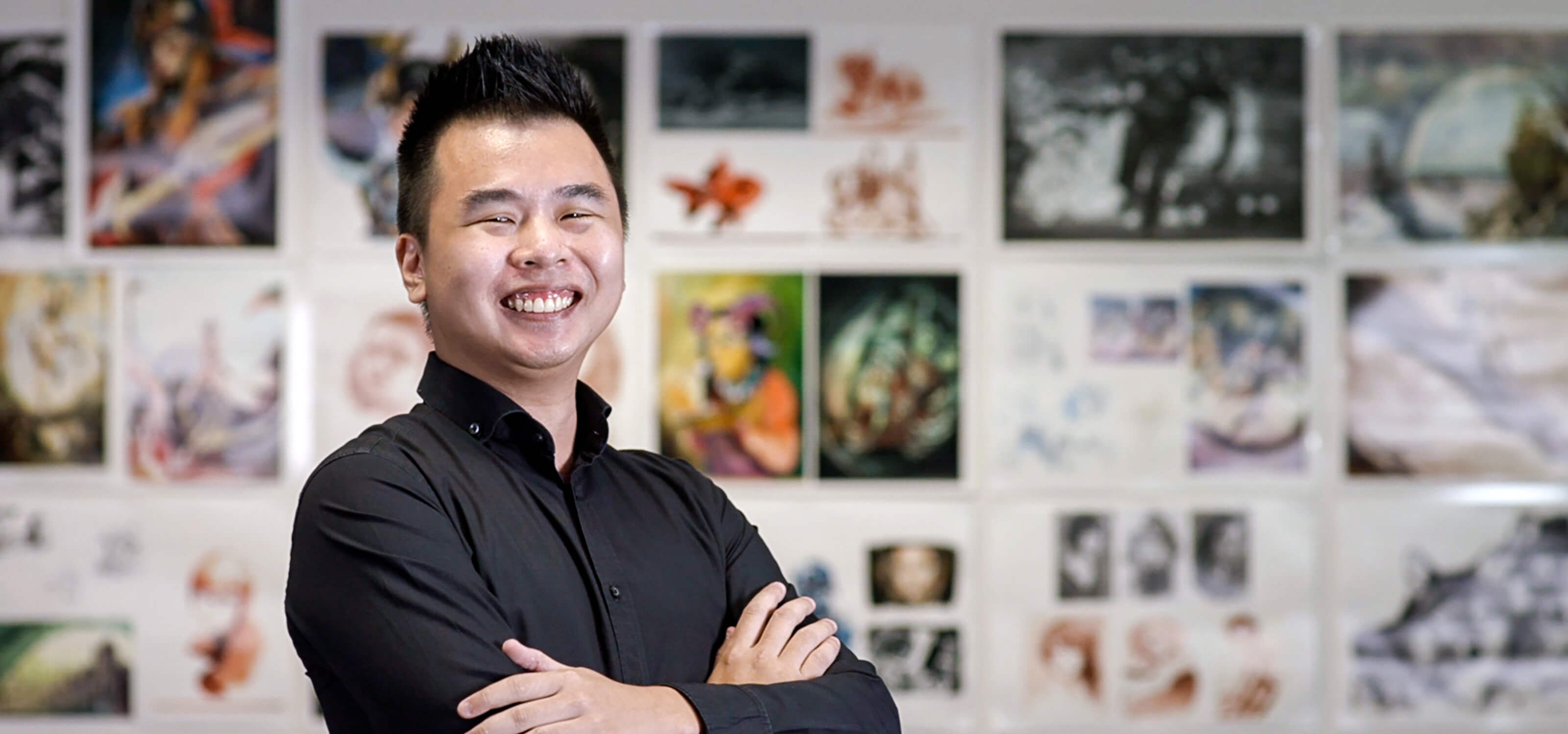 Joshua Ang stands in front of a colorful wall