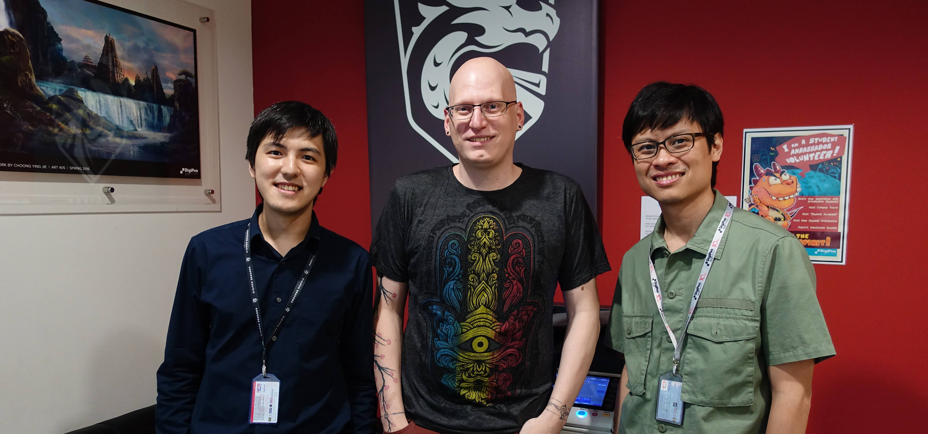 Howard Sin, Kevin Prior, and Gerald Wong pose smiling in an office on the DigiPen (Singapore) campus