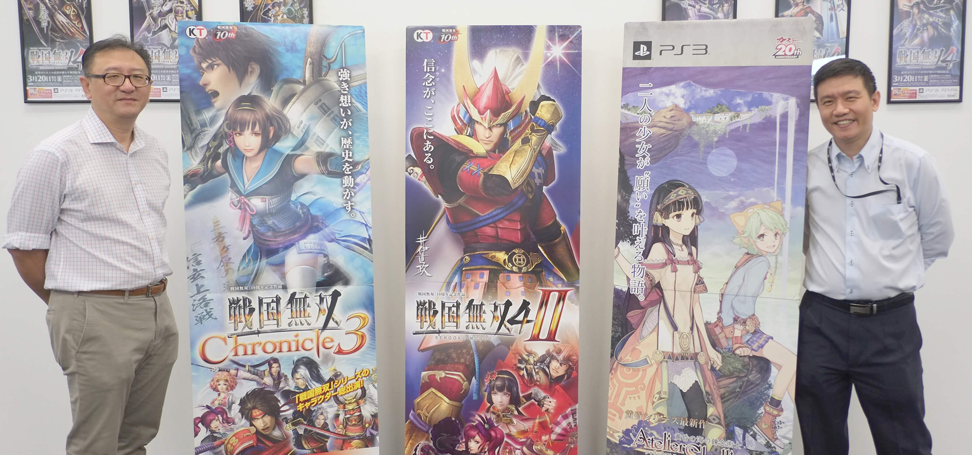 DigiPen (Singapore) representatives stand with vertical banners displaying Koei Tecmo video game titles