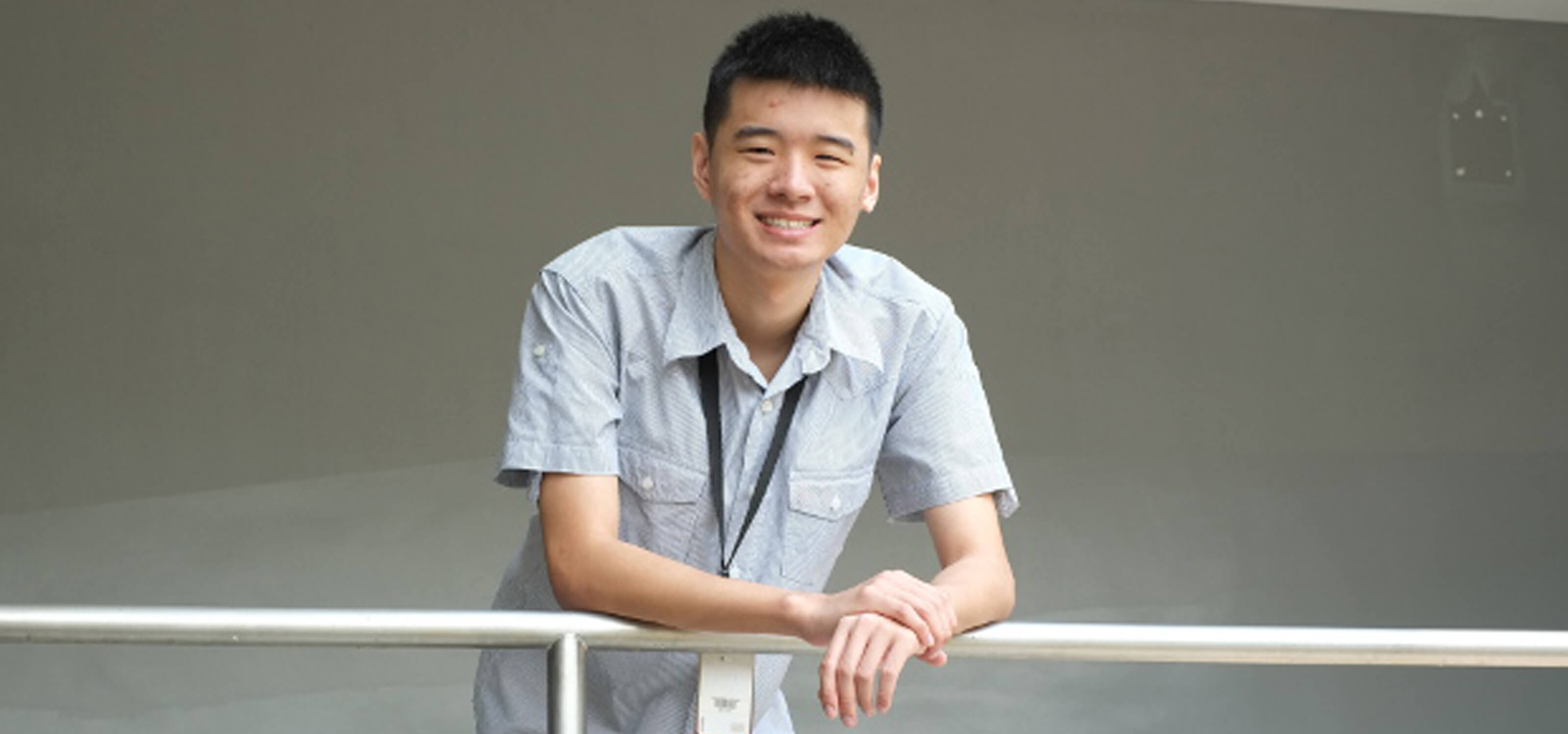 DigiPen (Singapore) student Tan Yao Wei leans on a metal railing posing for a photo