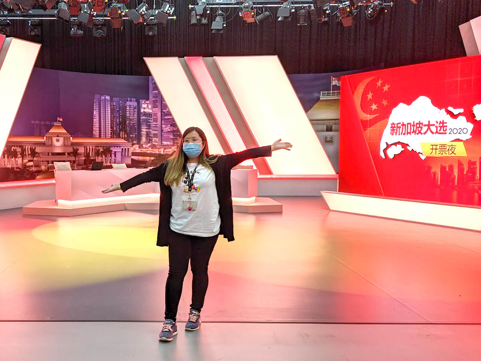 DigiPen alumna Carmen Chan stands on the set of a TV news show.