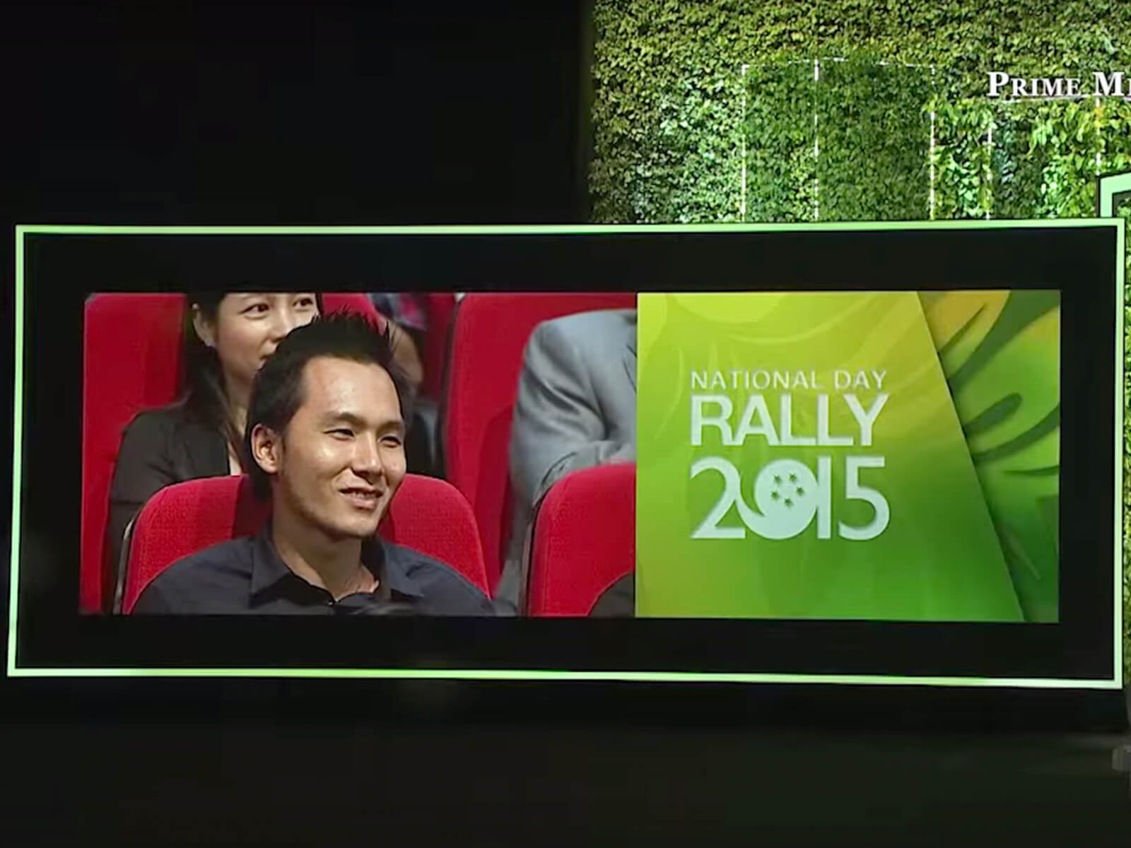 DigiPen alumnus Chen Zhangkai appears on a large screen next to Singapore Prime Minister Loong giving a speech on stage