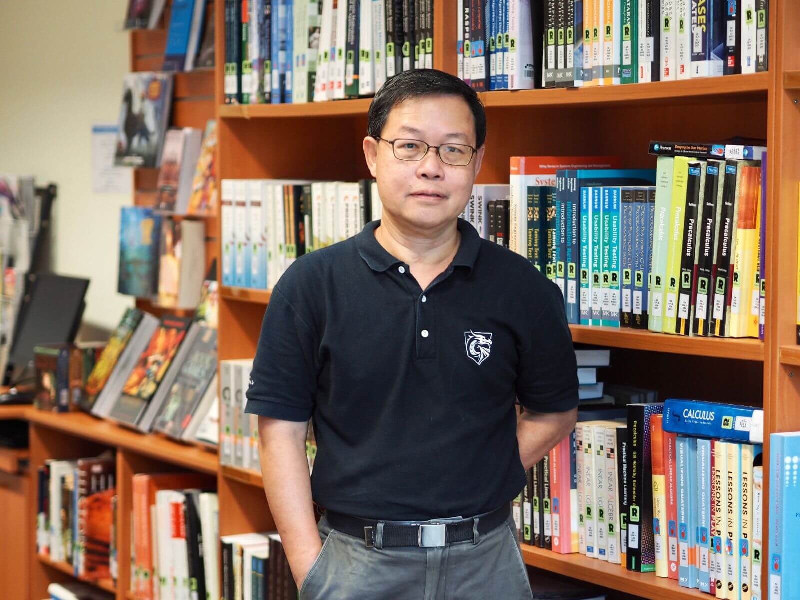 DigiPen Singapore Dept. Chair Fong Foo Hoong poses for a photo next to a bookcase