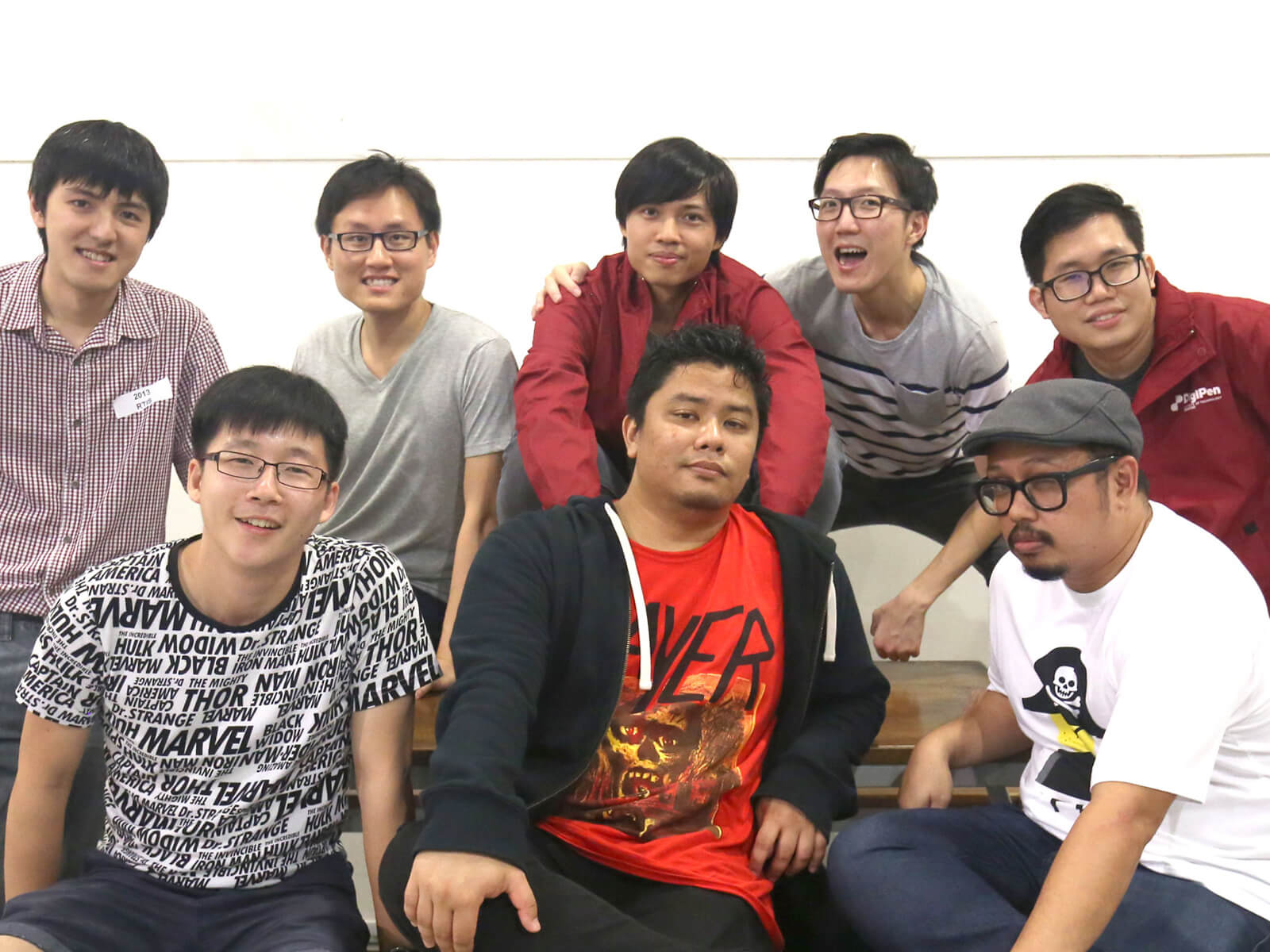 Eight DigiPen graduates pose for a photo standing or sitting at a picnic table