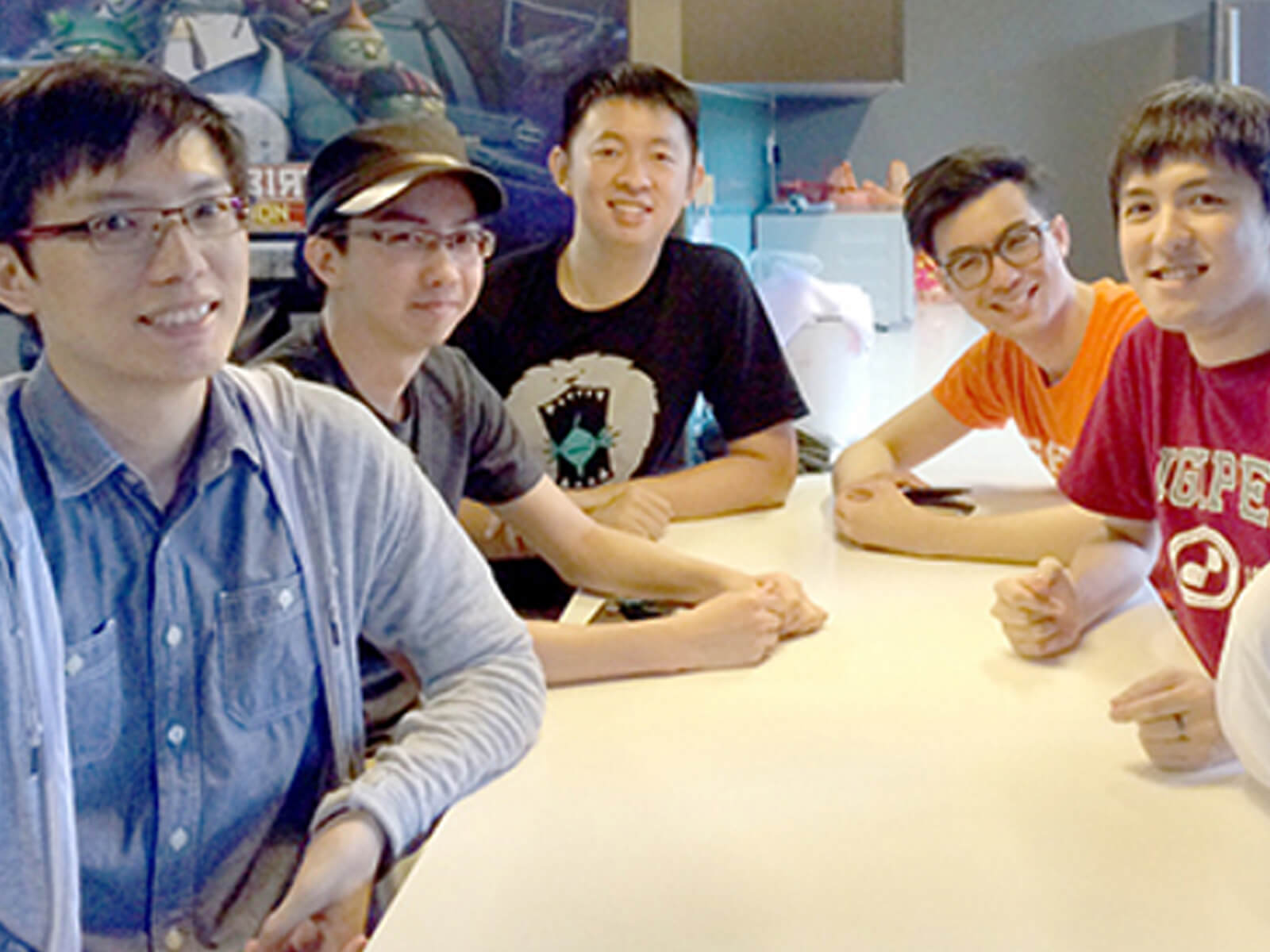 Six DigiPen alumni pose for a photo sitting at a table