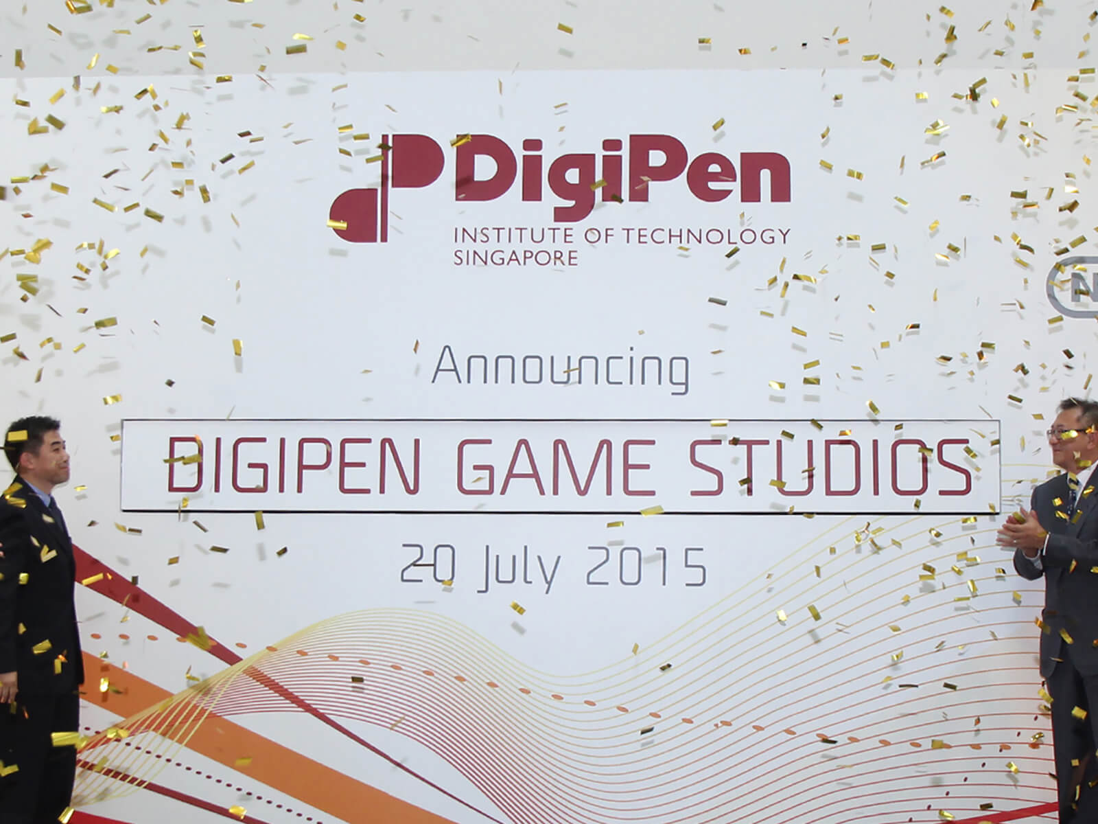 Representatives of DigiPen applaud the unveiling of the DigiPen Game Studios onstage as gold confetti falls from above