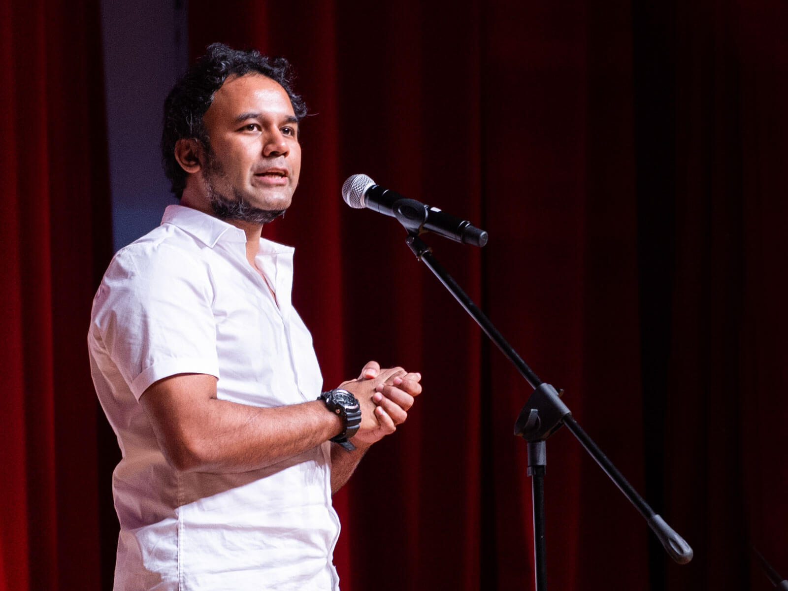 Rahul Nath stands before a microphone.