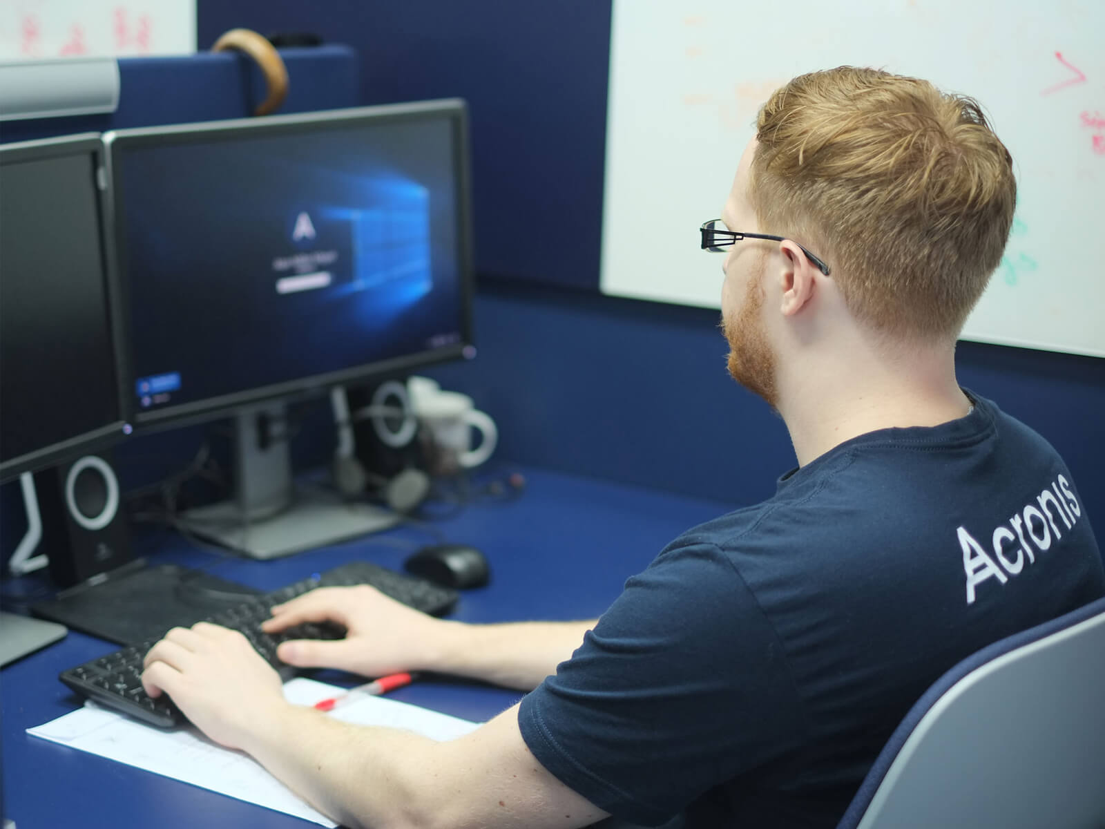 DigiPen Graduate Alan Miller working at a computer at a blue desk