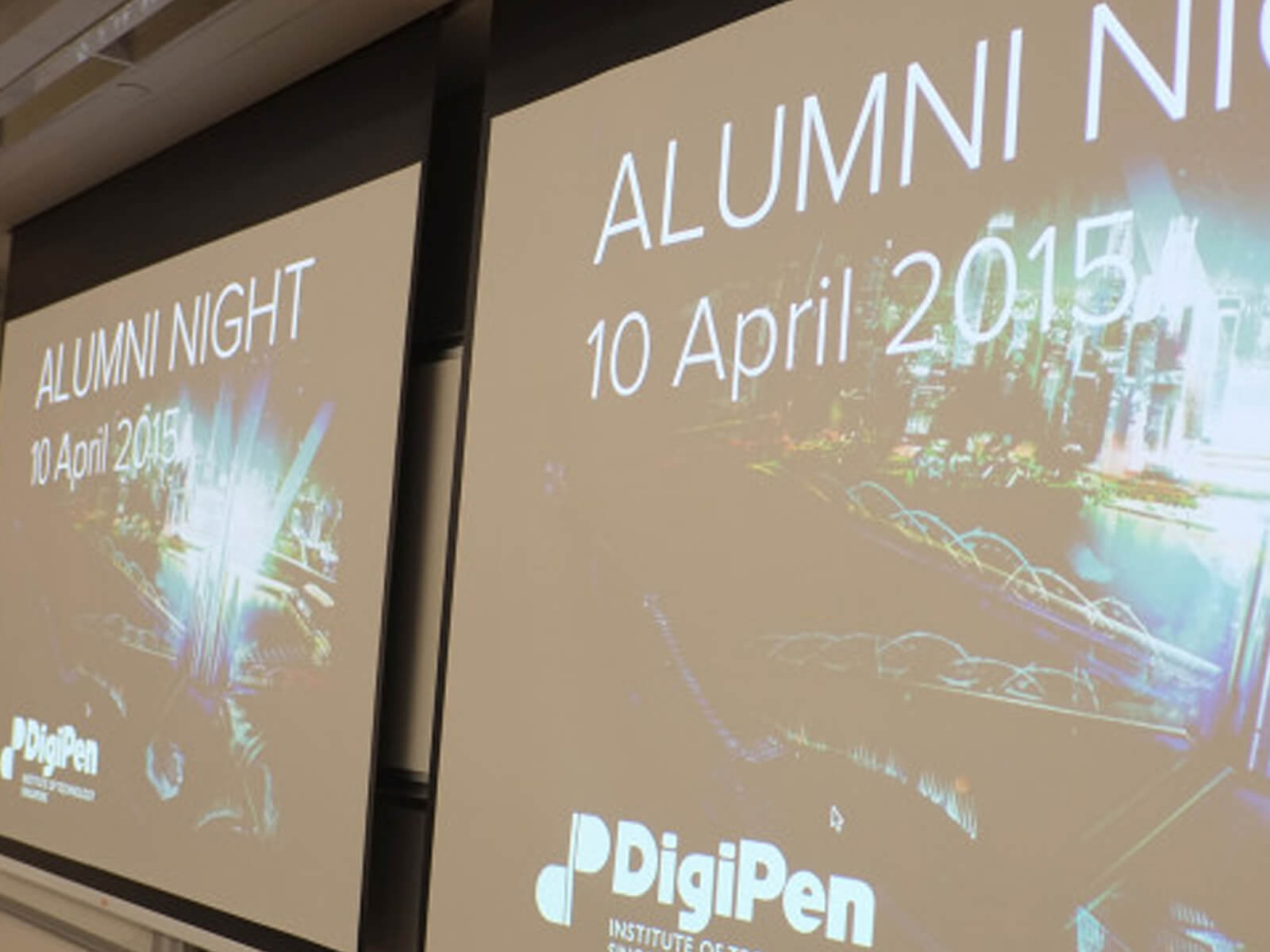 A projection screen displays "Alumni Night, 10 April 2015" and a graphic of a shining futuristic city