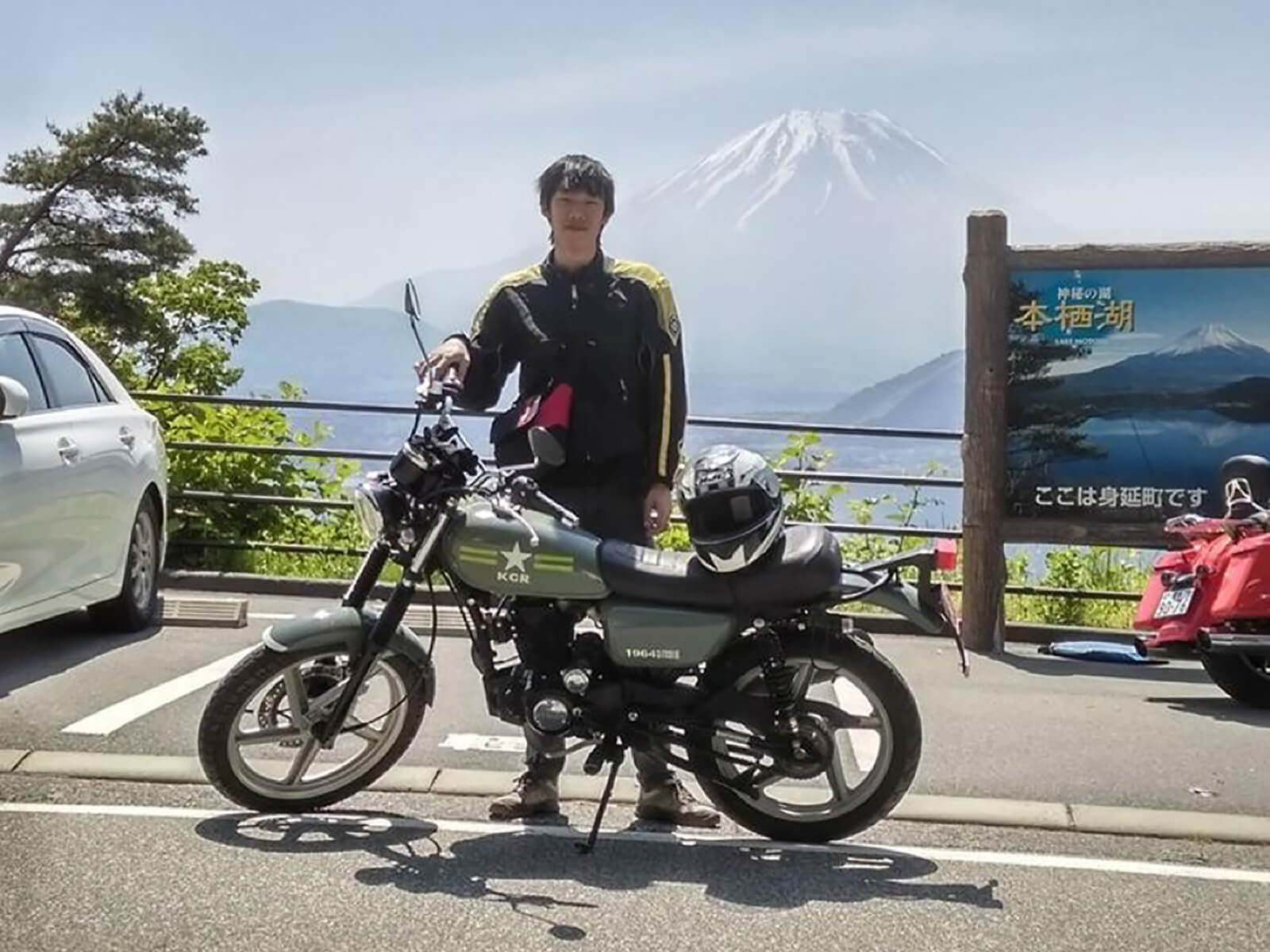 DigiPen (Singapore) alumnus Max Chew poses with a motorcycle, with a mountain in the background