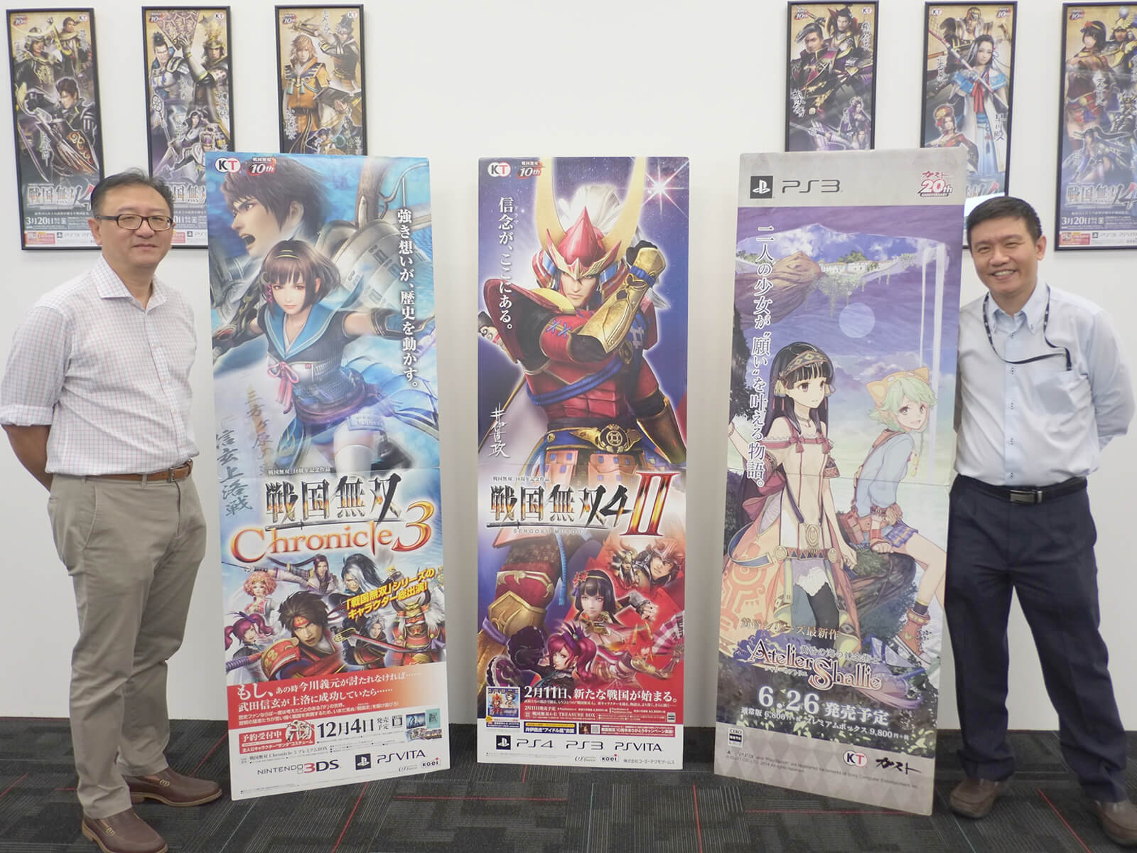 DigiPen (Singapore) representatives stand with vertical banners displaying Koei Tecmo video game titles