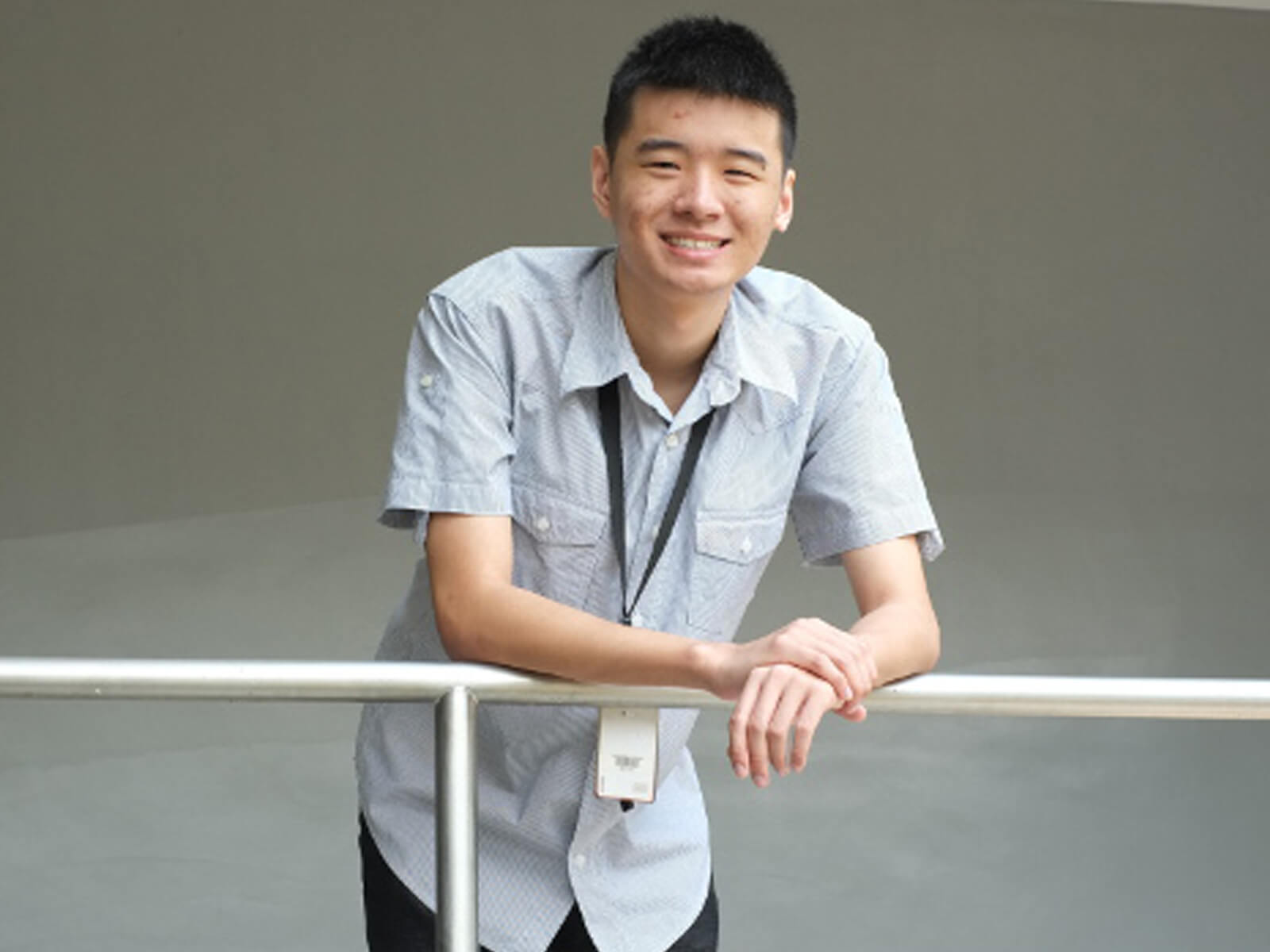 DigiPen (Singapore) student Tan Yao Wei leans on a metal railing posing for a photo