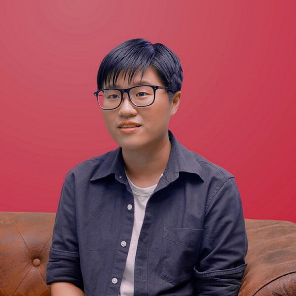 Alumna Gabrielle Tan sits on a brown leather sofa