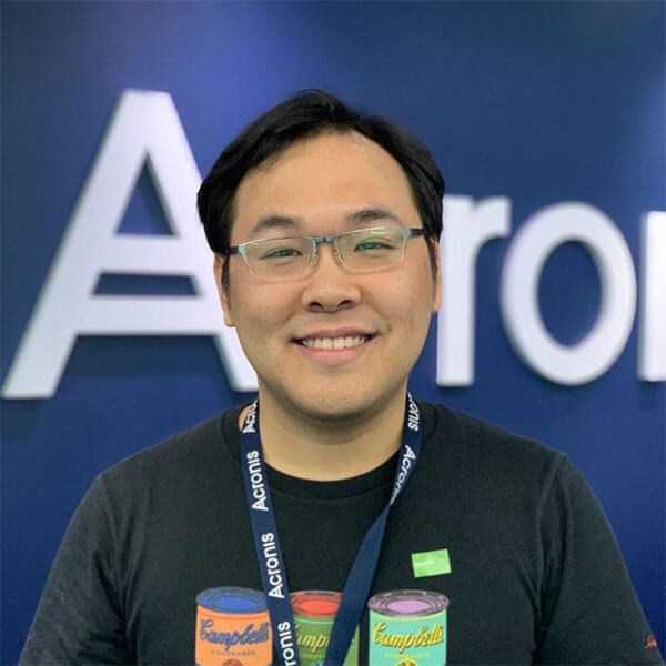 Ho Shuyuan smiling and standing in front of blue backdrop