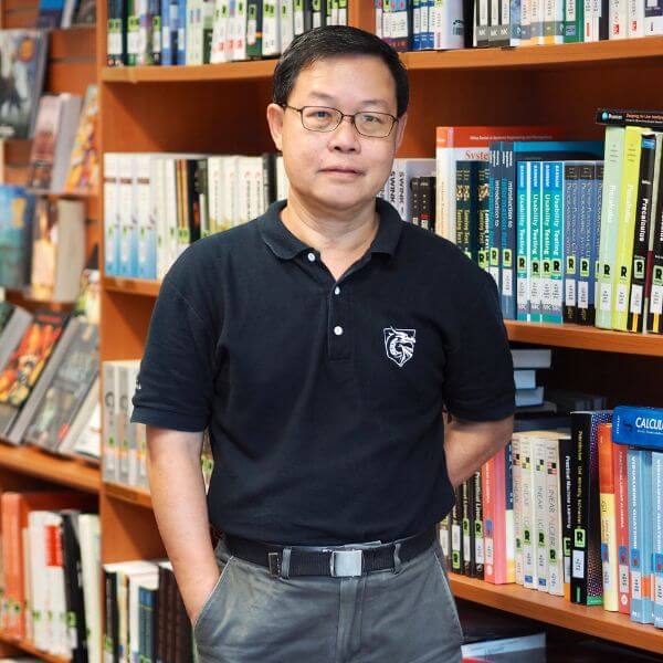 DigiPen Singapore Dept. Chair Fong Foo Hoong poses for a photo next to a bookcase