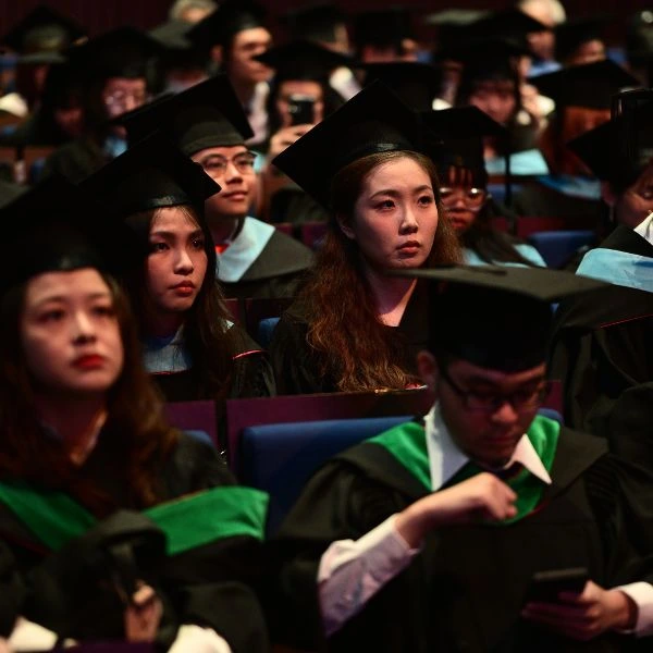 Students sit at a graduation ceremony.