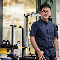 DigiPen (Singapore) alumnus Truman Ang Zheng Tai poses in his workspace