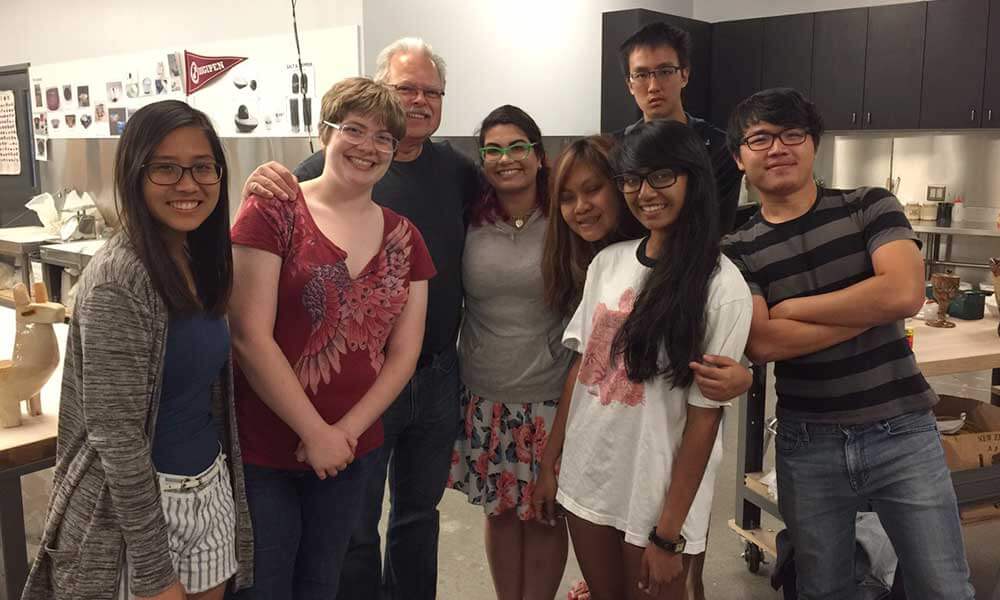 OIP and Redmond campus students pose with a faculty member inside a classroom