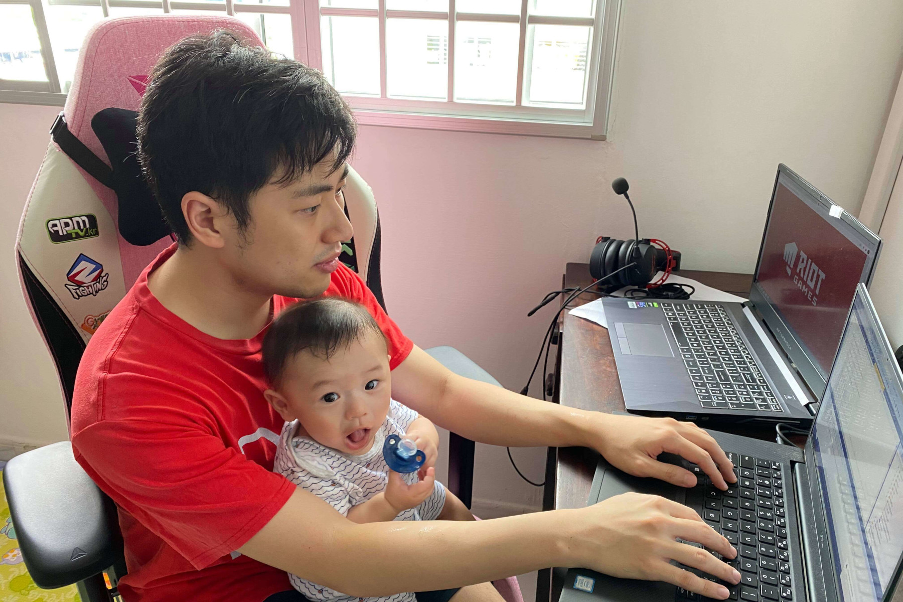 Kenny Chong working from home with his baby.