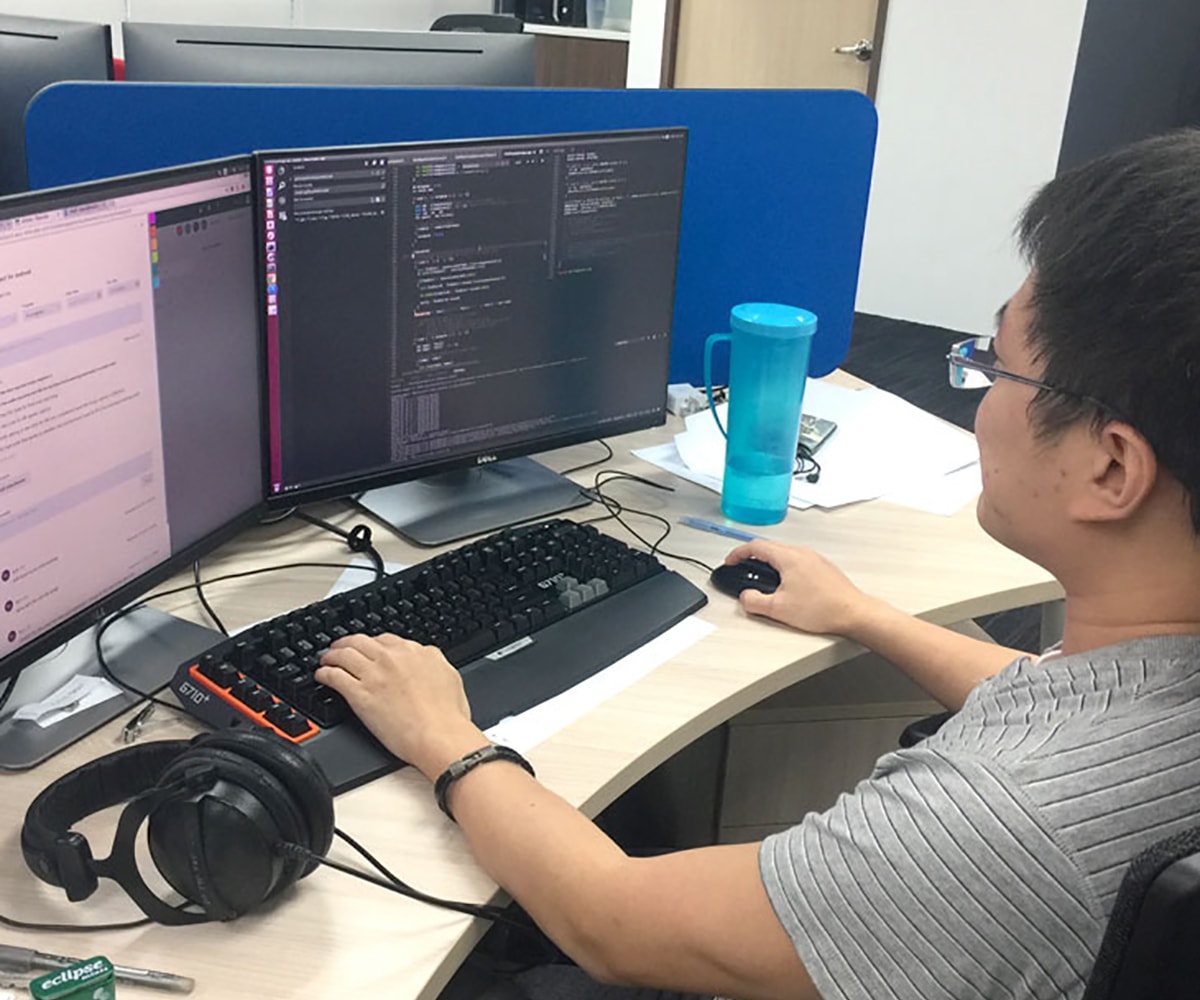 DigiPen Singapore alumnus Ryan Lim works at his desk in the NetVirta office