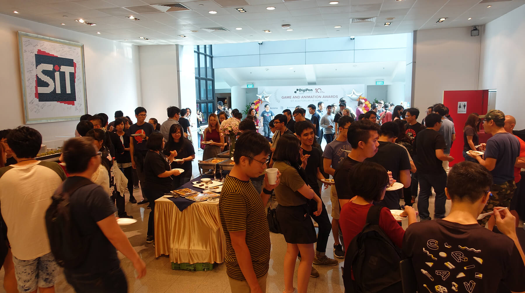 Many students mingle and enjoy refreshments on campus in celebration of the DigiPen Game and Animation Awards.