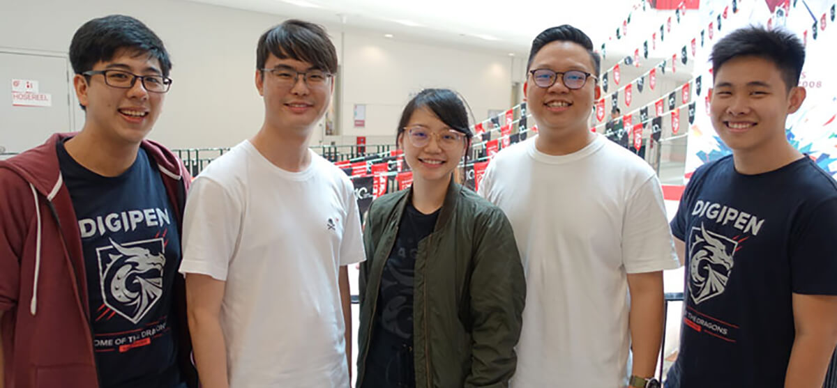 DigiPen (Singapore) Student Ambassadors Adriel, Kenneth, Pamphylia, Samuel, and Ricson pose in front of black-and-red pennants