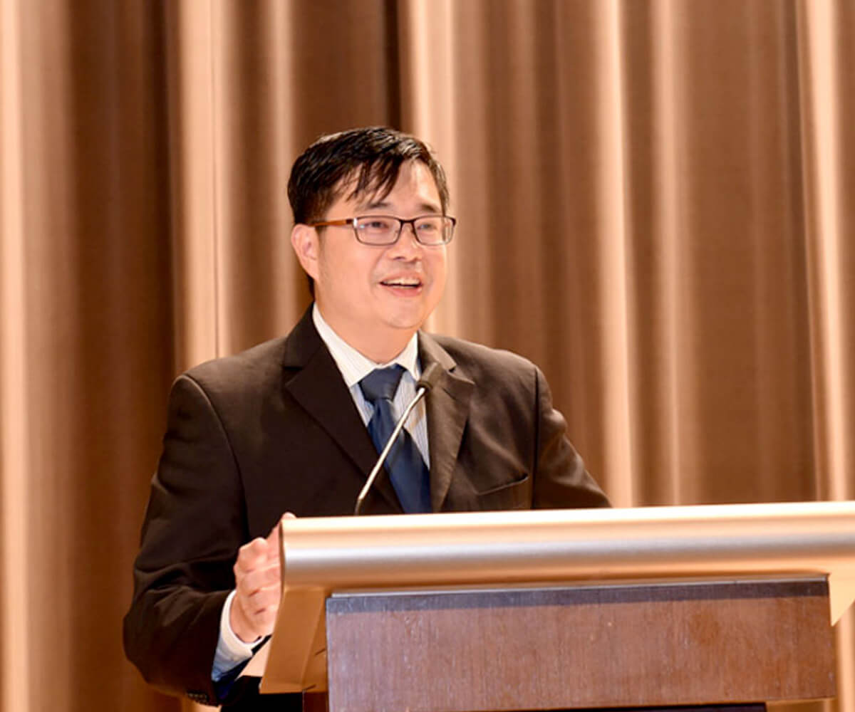 Dr. Edward Sim speaking at a lectern