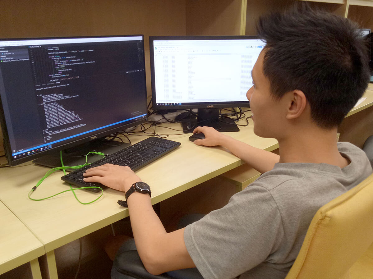 DigiPen (Singapore) BS in Game Design alumnus Lim Sing Gee works at a desk in front of 2 monitors