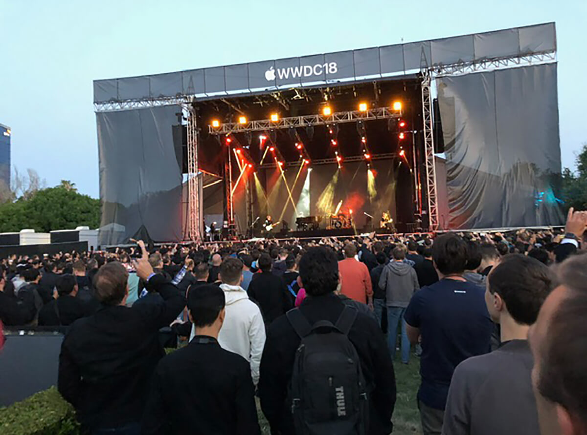 A crowd gathers in front of a large outdoor stage at the Apple Worldwide Developers Conference 2018.