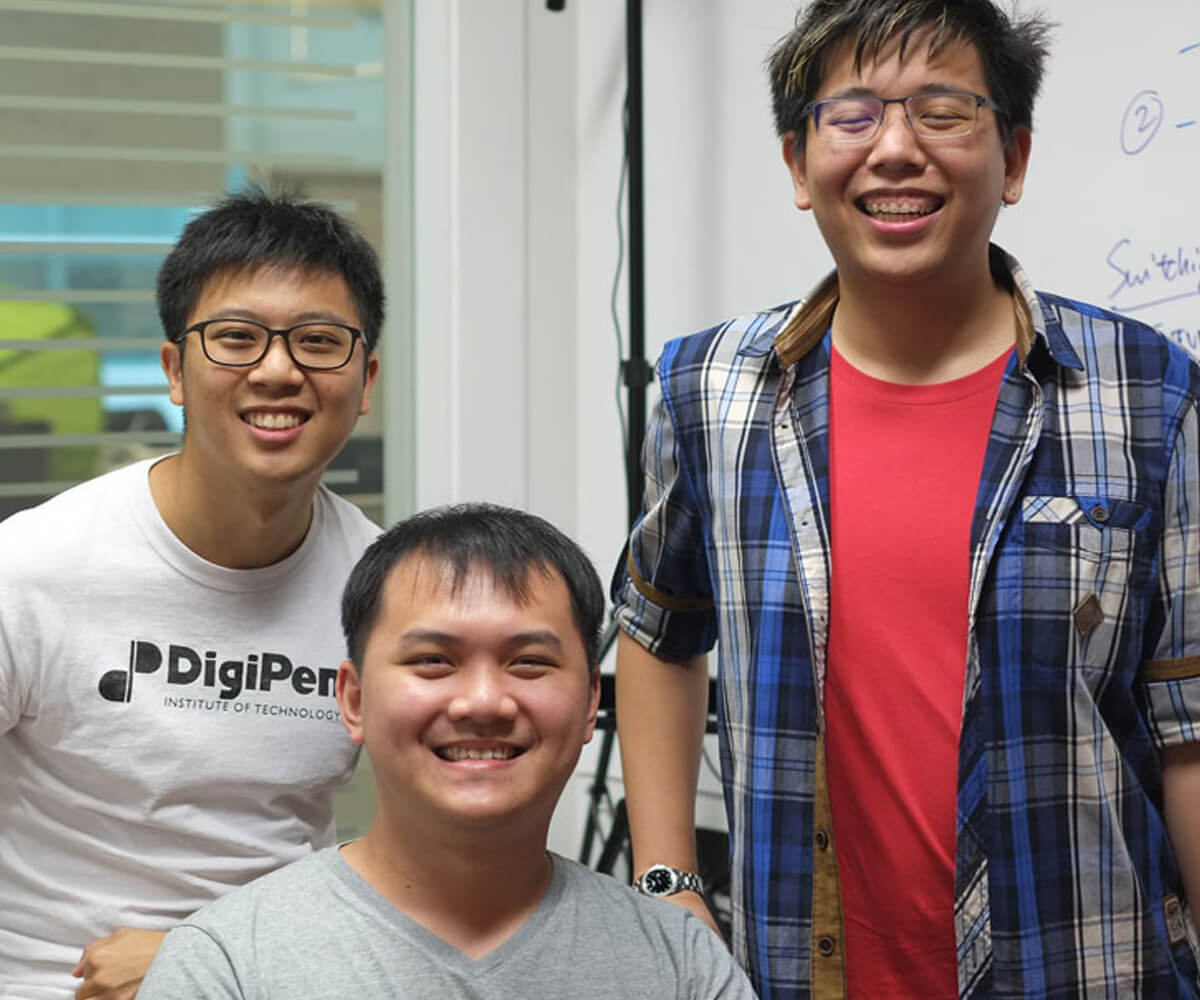 Graduates Michael Tay, Julian Teh, and Koh Naimin pose for a photo in an office