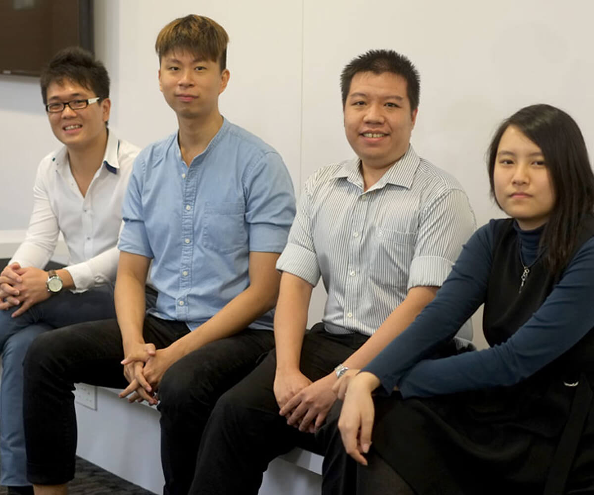 DigiPen interns at ST Electronics pose for a photo sitting on a bench