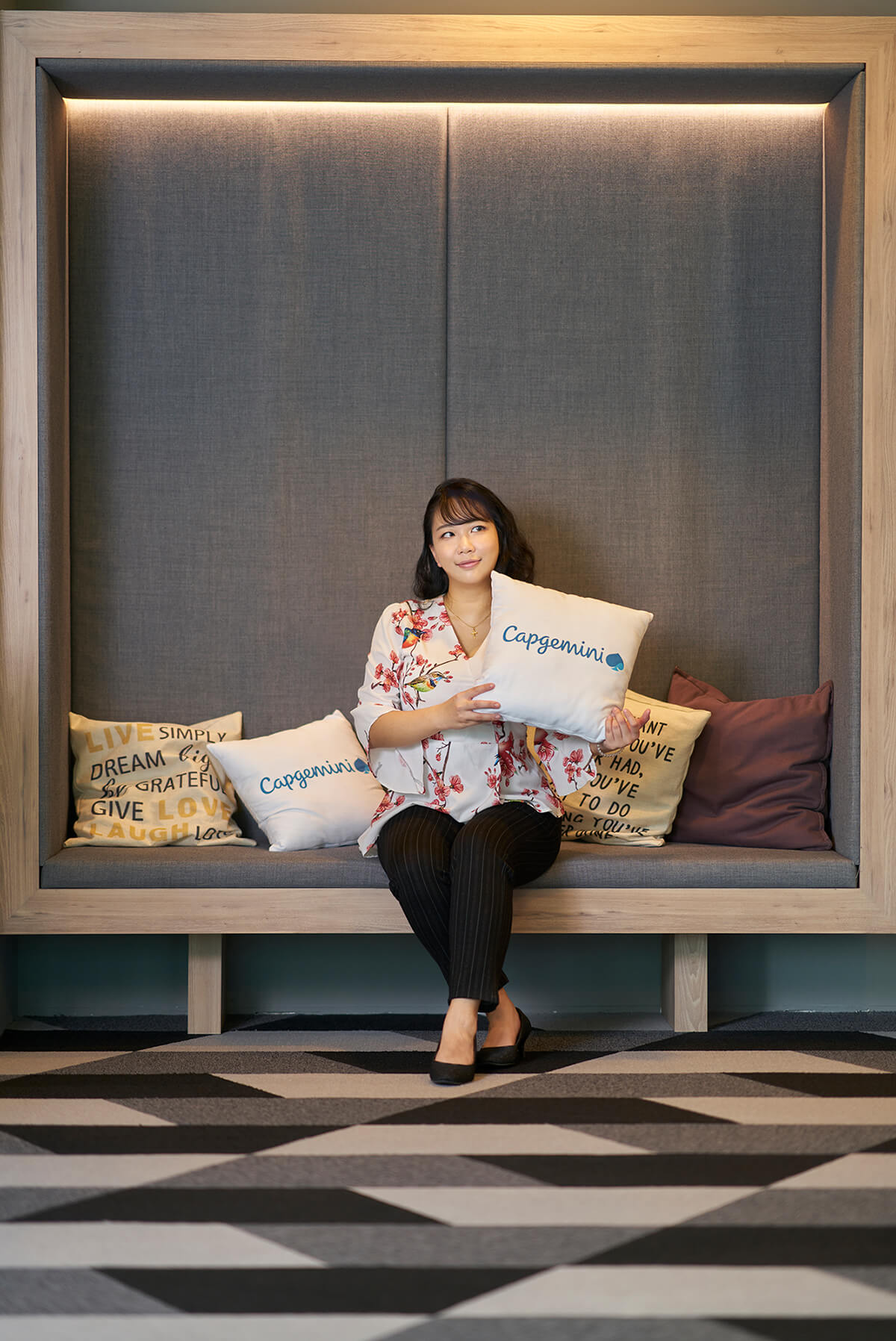 DigiPen (Singapore) grad Sherilyn Kan poses with a Capgemini pillow