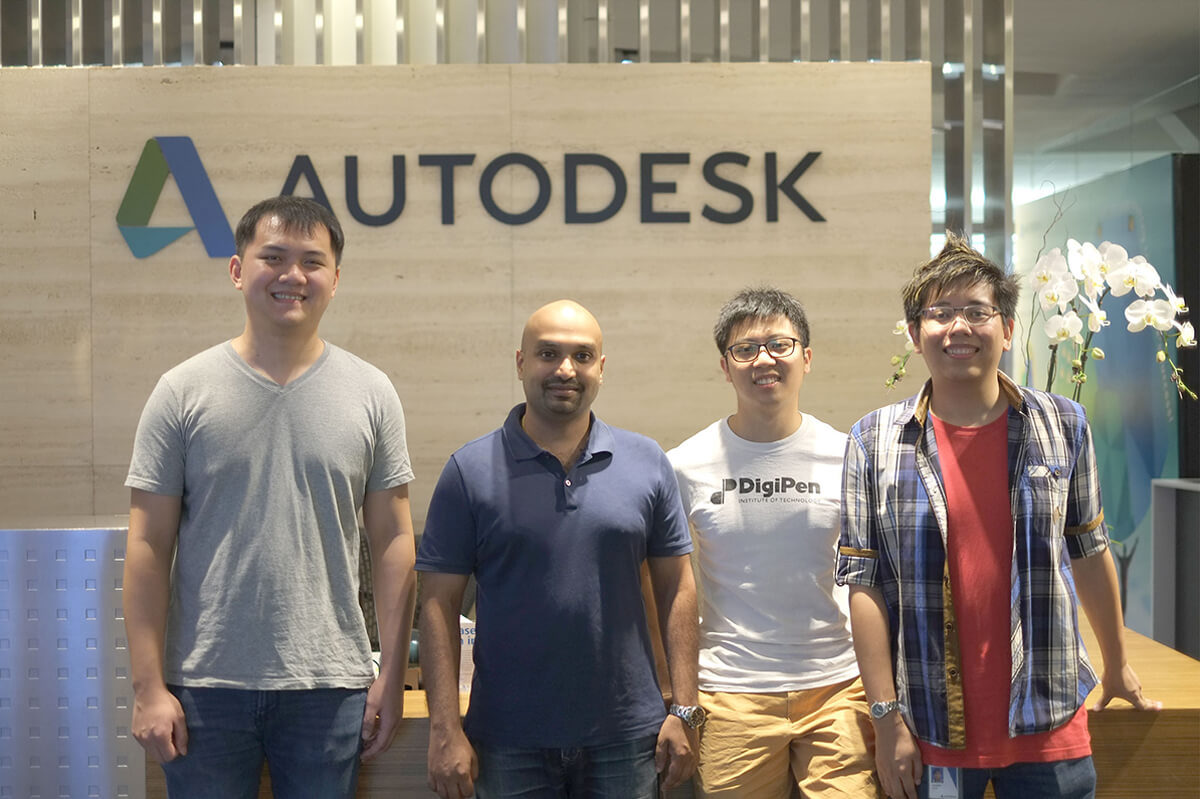 DigiPen graduates pose for a photo with Autodesk logo on a beige wall behind them