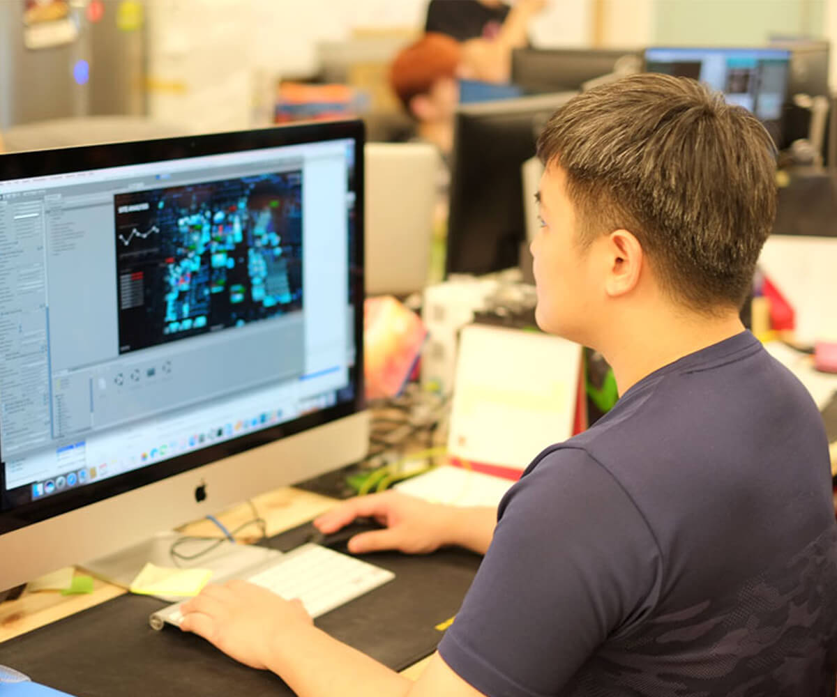 Graduate Wilson Phoo sits at a desk in front of a computer