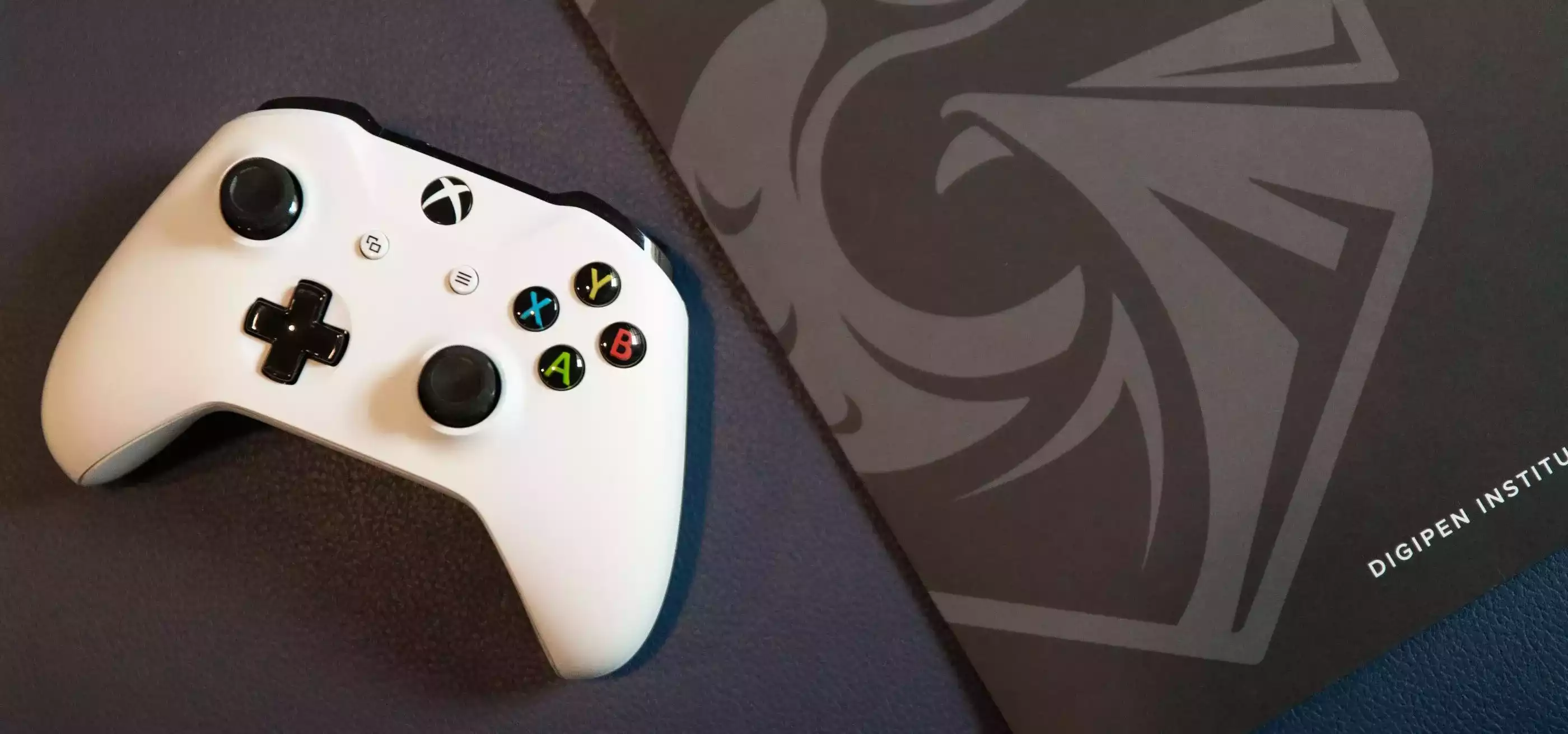 Xbox controller next to a DigiPen folder.