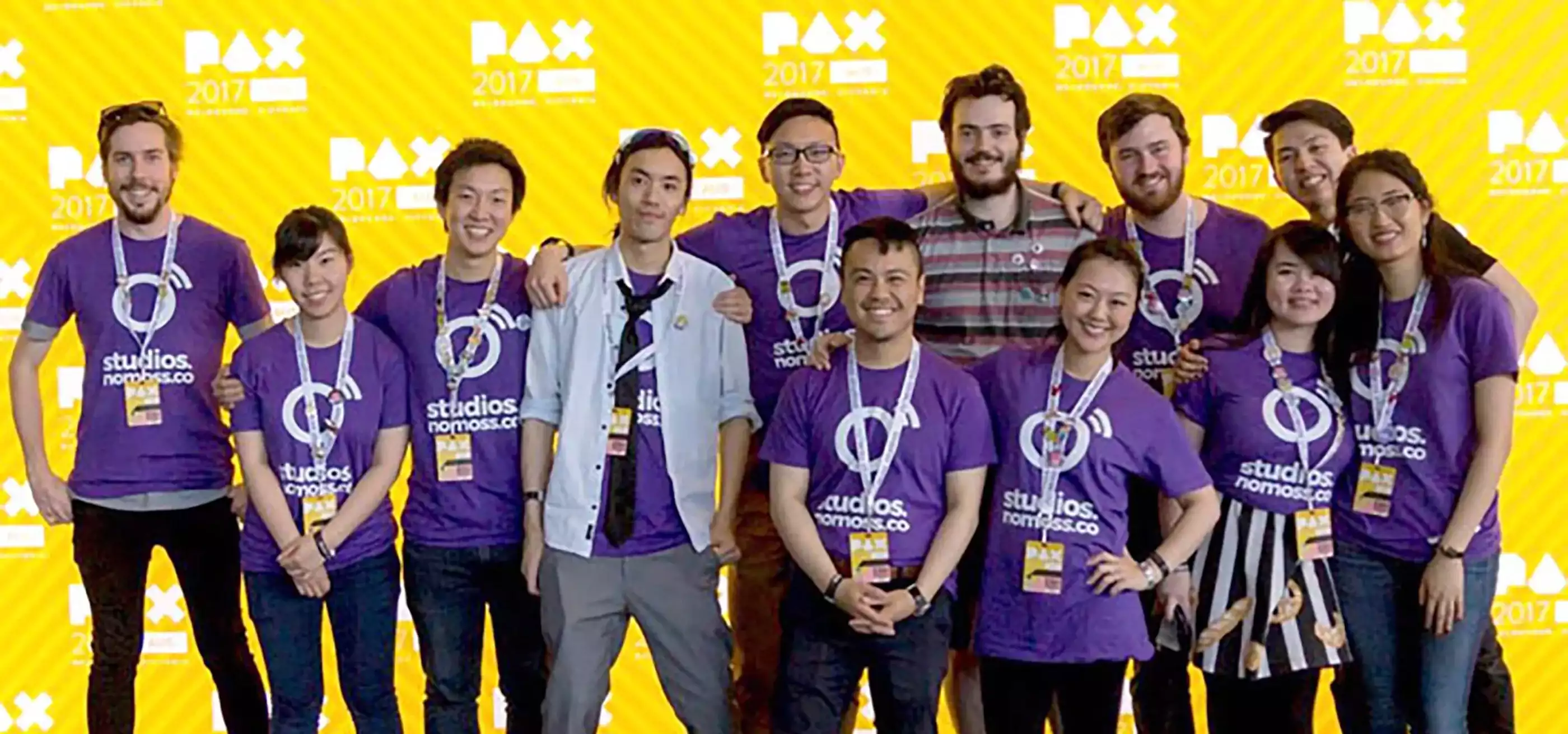 DigiPen (Sinagpore) alumnus Chen Zhiming poses with No Moss Co coworkers in front of a PAX 2017 step-and-repeat