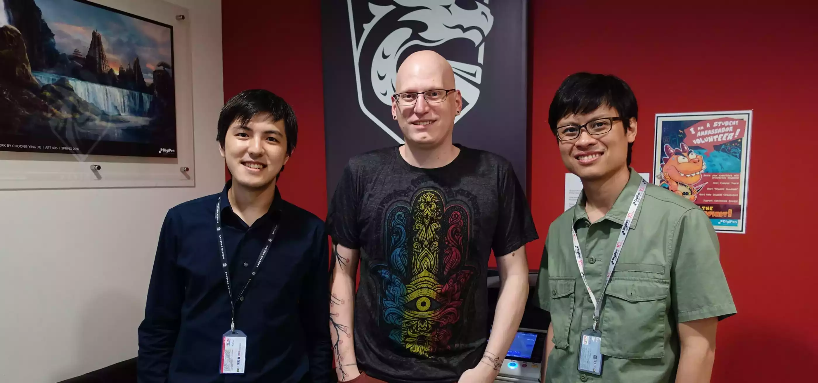 Howard Sin, Kevin Prior, and Gerald Wong pose smiling in an office on the DigiPen (Singapore) campus