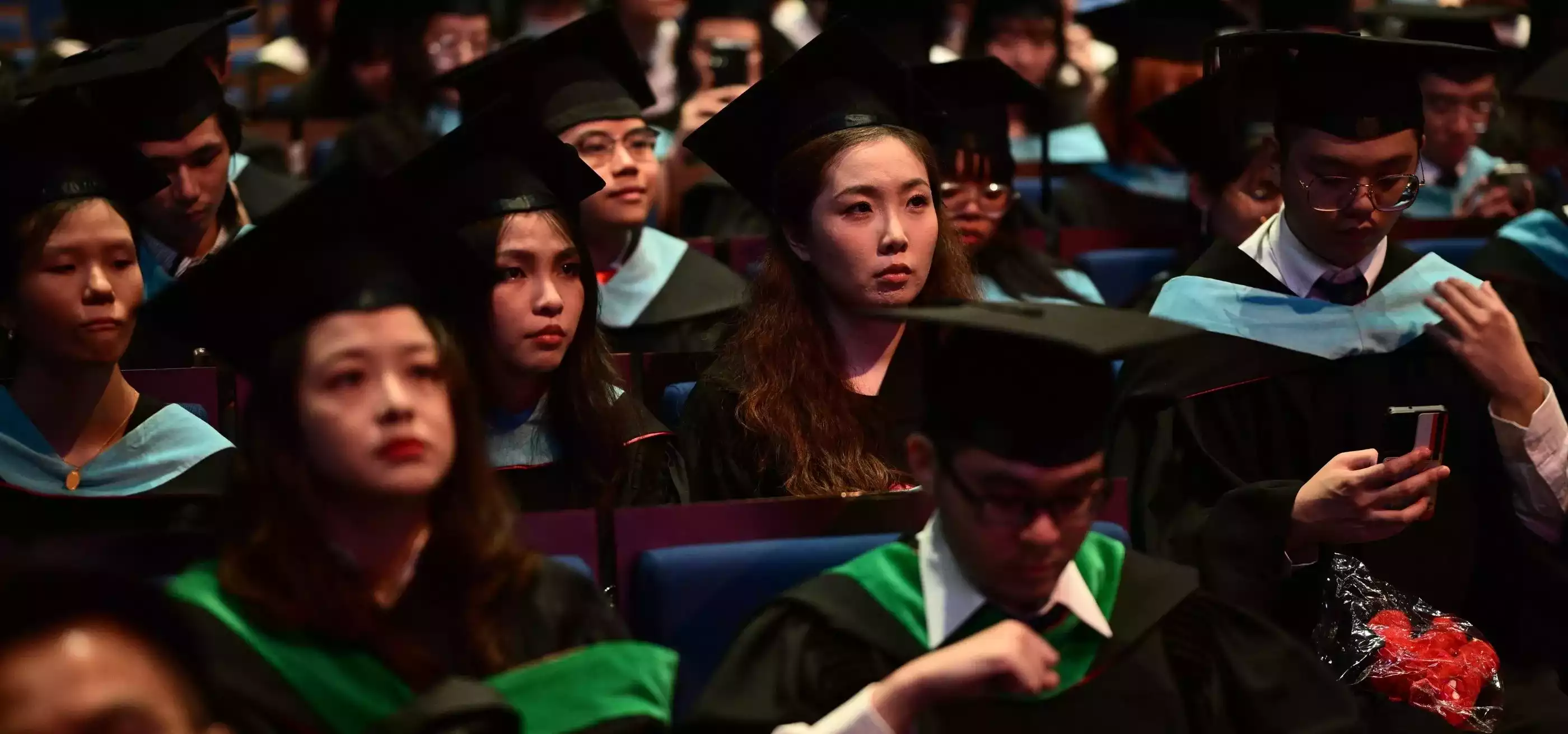 Students sit at a graduation ceremony.